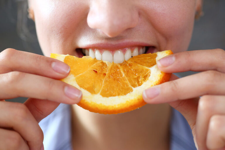 woman eating orange slice